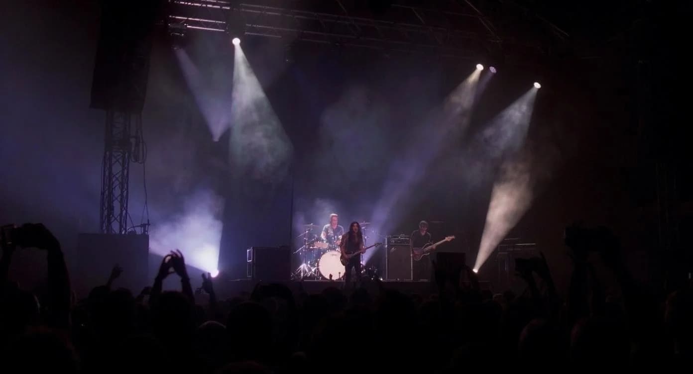 KI-generiertes Beispiel für Konzertfotografie: Generiere eine Aufnahme eines Rockkonzerts mit dramatischen Bühnenlichteffekten und Silhouetten.
